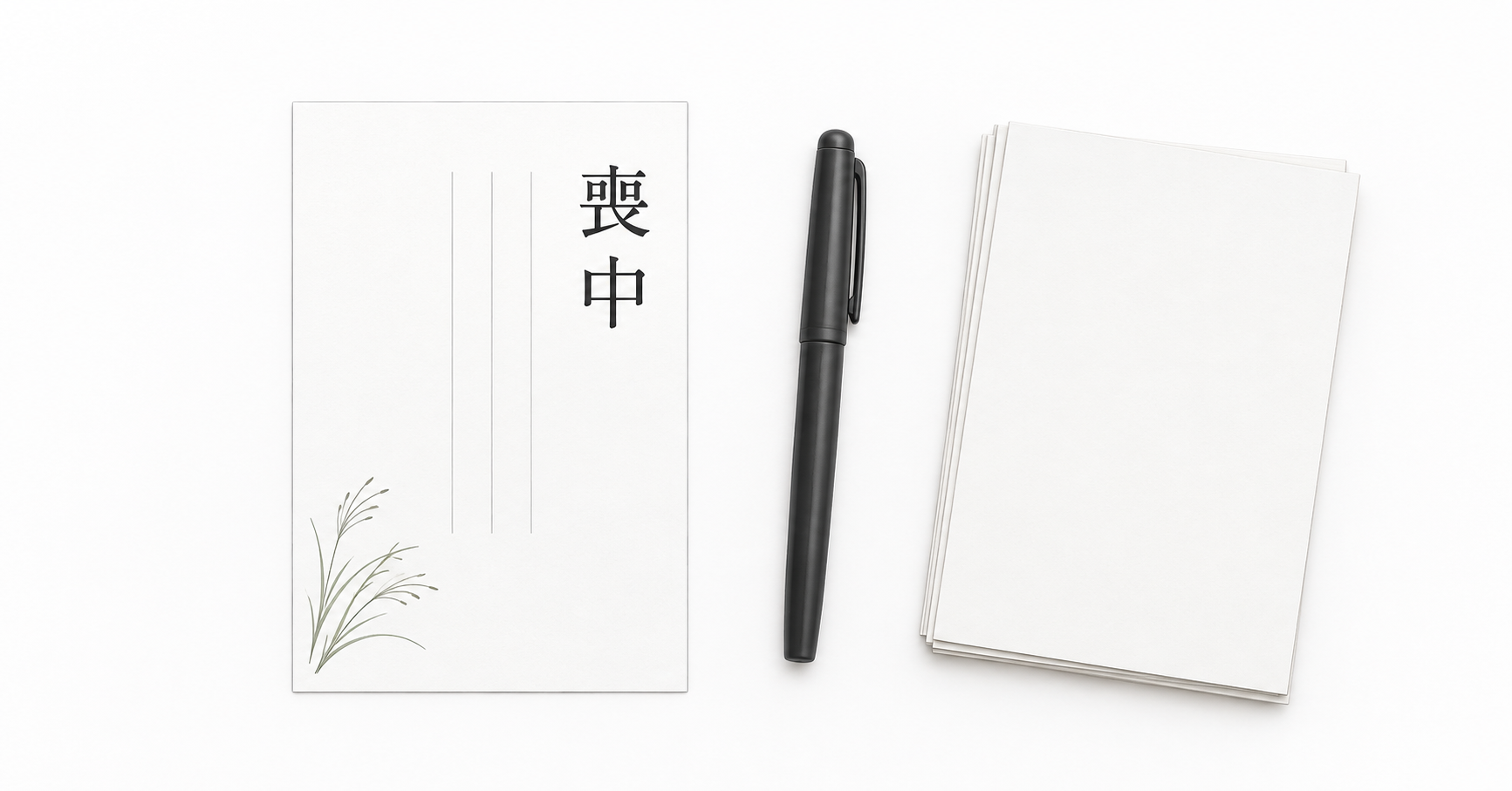喪中の文字と控えめな草の絵柄が入った白いはがき、筆記具と無地のはがき